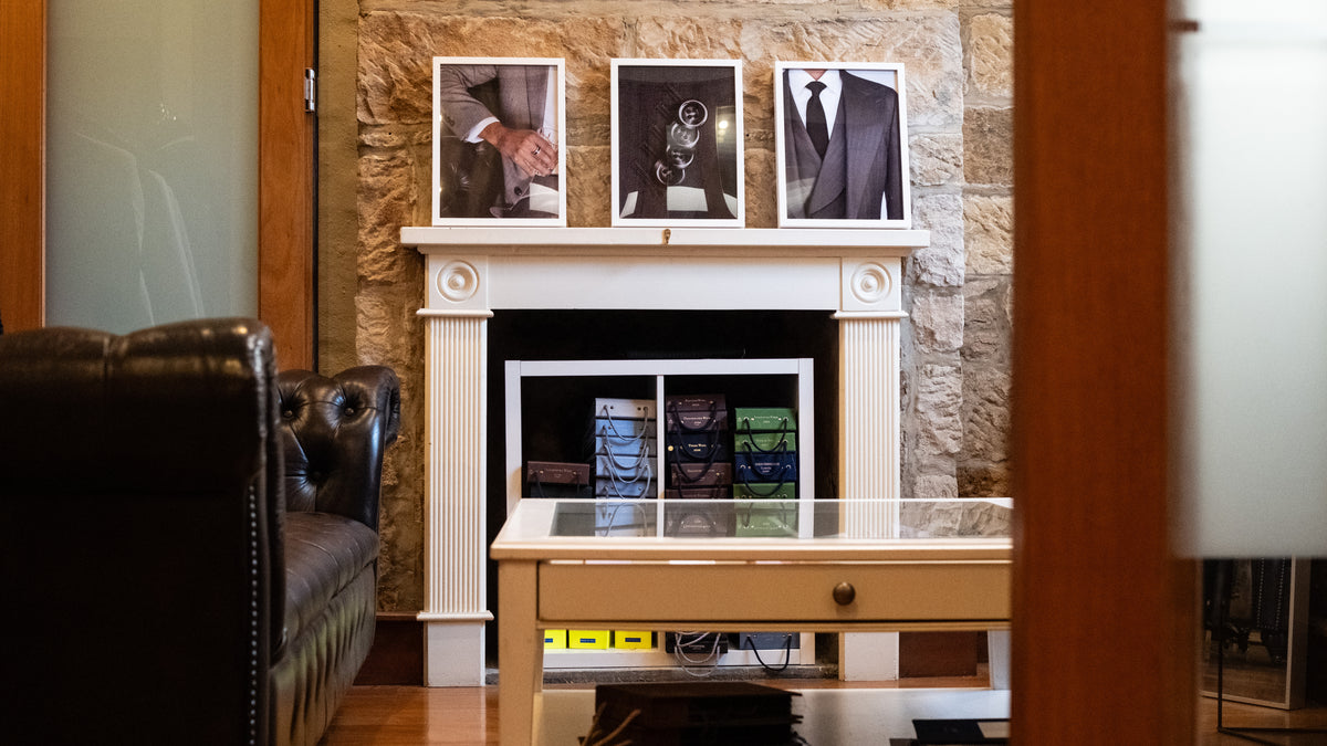 Cloth books stacked in the hearth beneath three framed prints