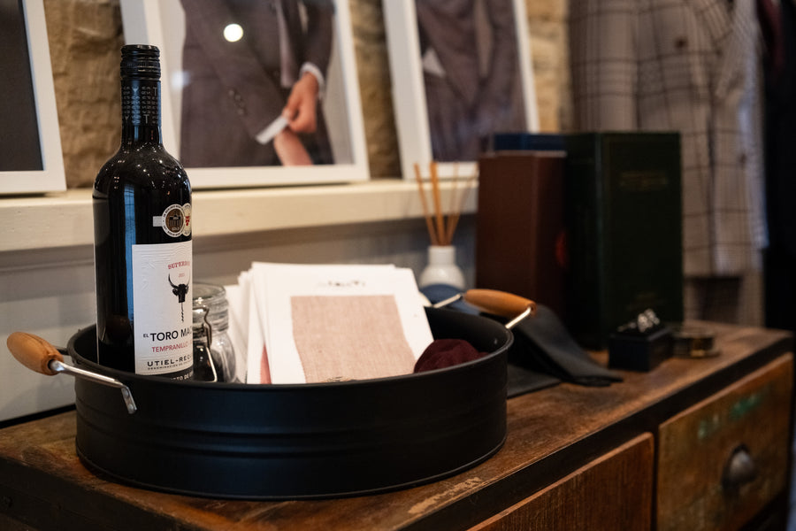 Swatches, a bottle of tempranillo and cards on the sideboard