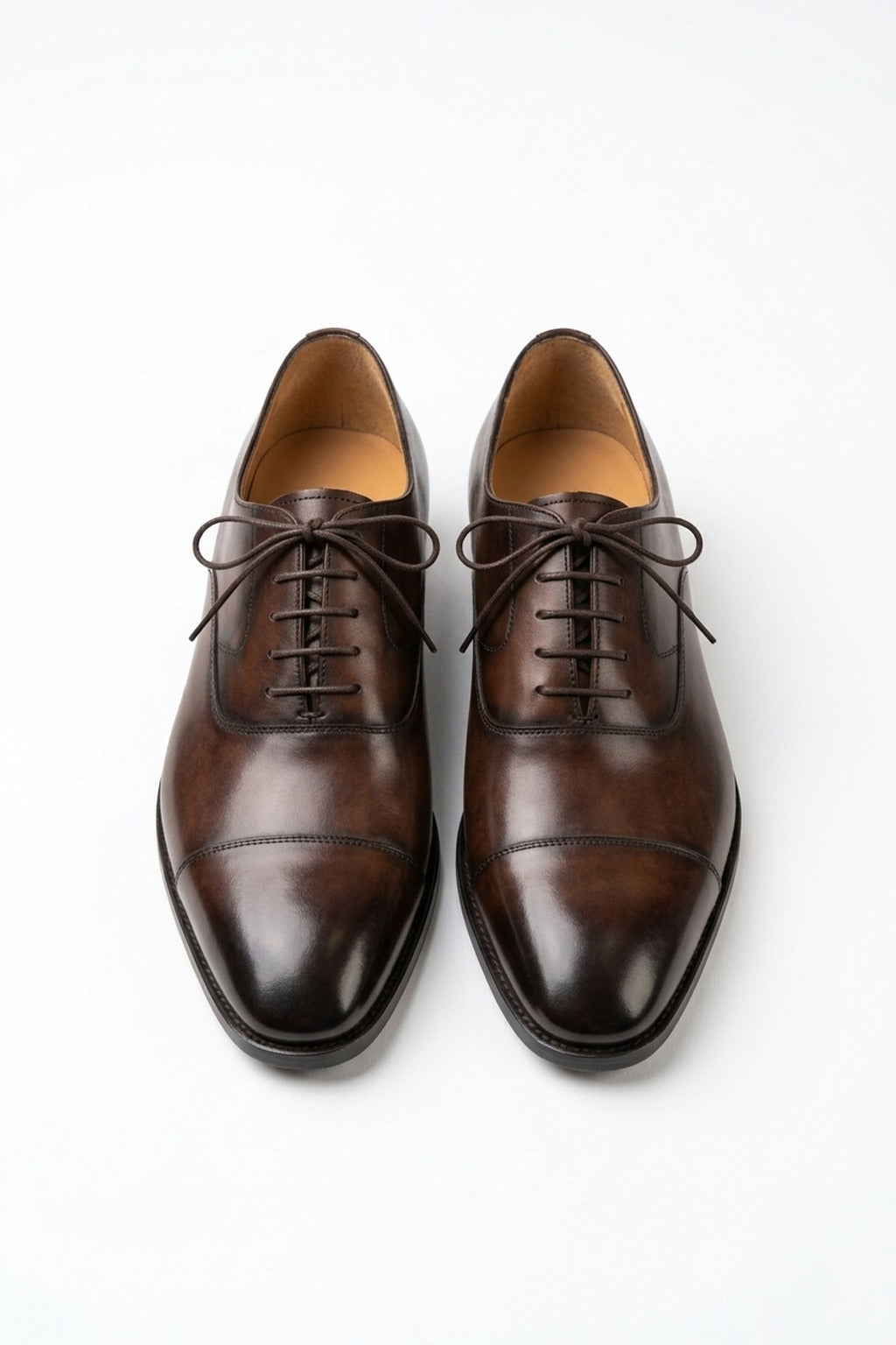 The Konbanwa Square-Toe Triple-Stitched Brown Oxford pair on white, top-down view of the burnished cap toe