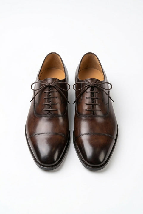 The Konbanwa Square-Toe Triple-Stitched Brown Oxford pair on white, top-down view of the burnished cap toe