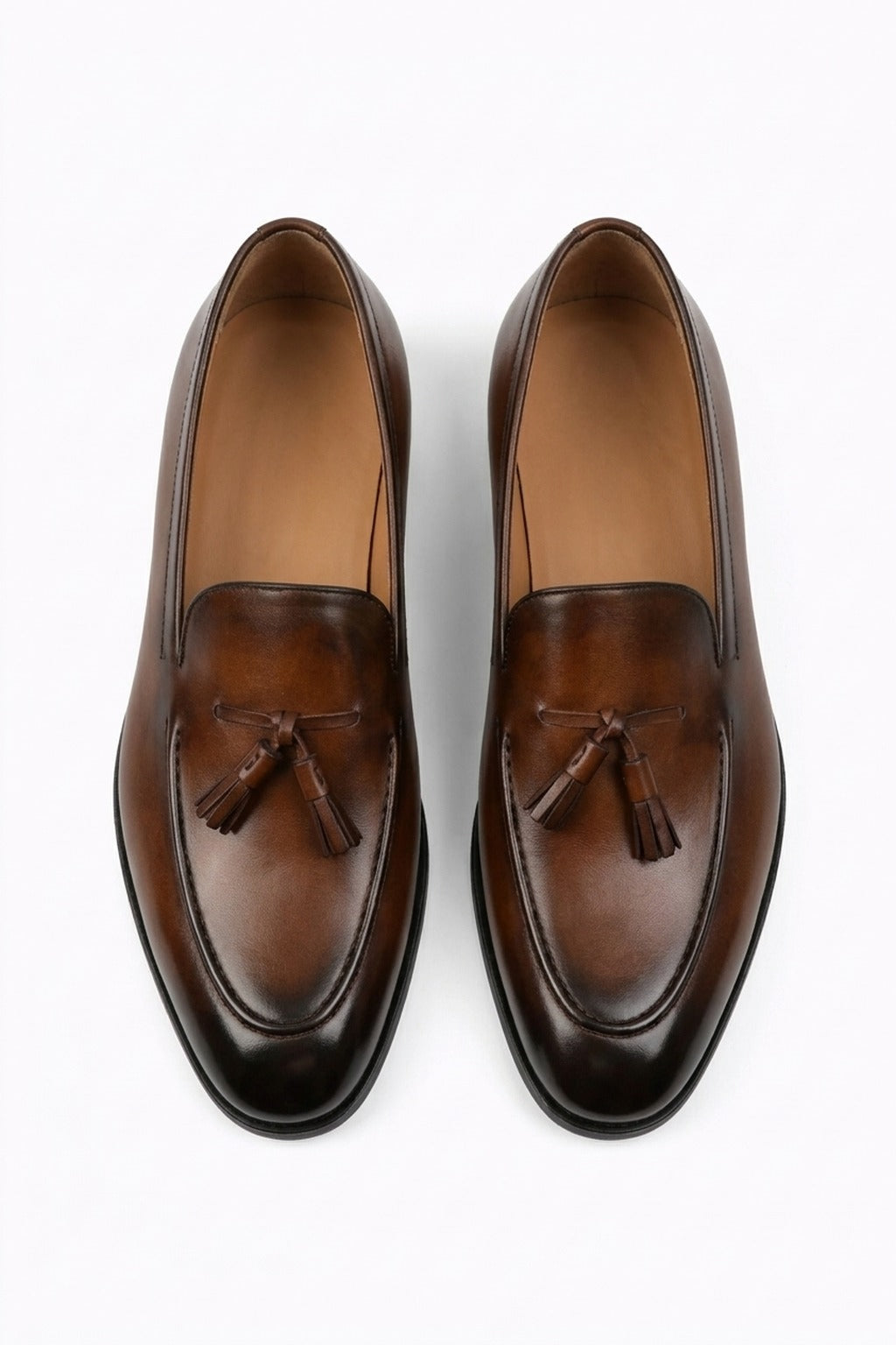 The Lukas Light Brown Leather Tassel Loafer pair on white, top-down view of the burnished apron and tassels
