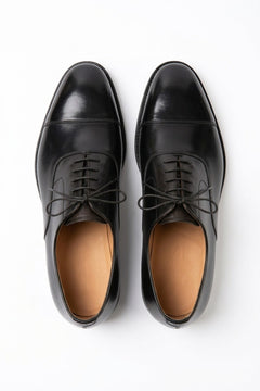 The Maison Soft Leather Black Derby pair on white, top-down view of the polished cap toe