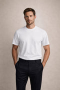The Essential White Tee, front view on a model with navy trousers, hands in pockets